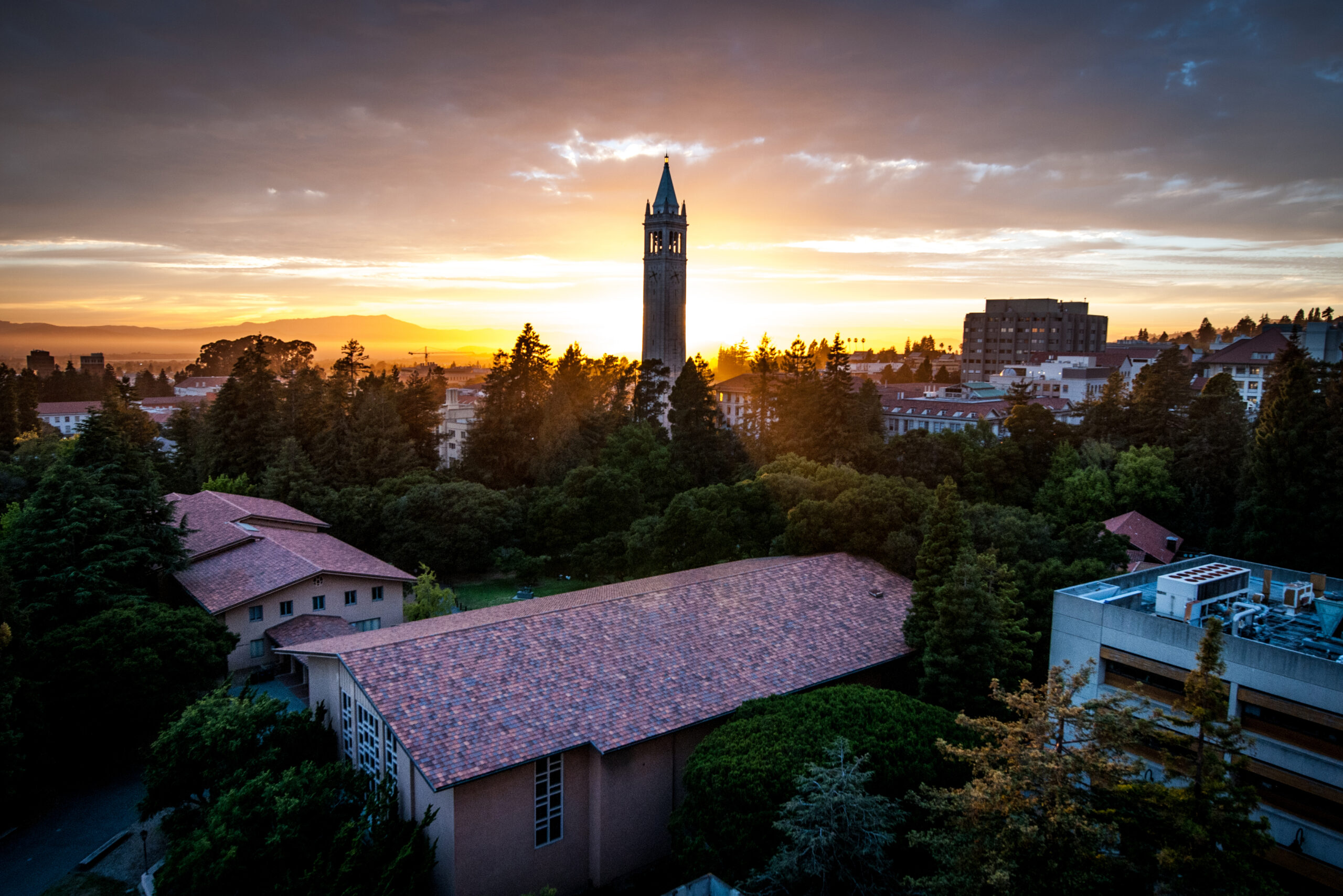 Aerial view of campus looking towards the Campanile and the bay at sunset.